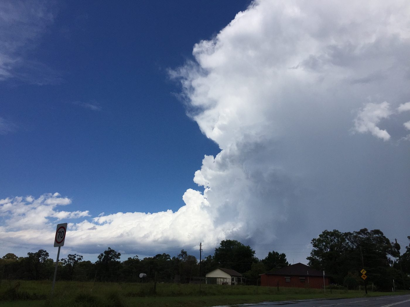 A bright white cumulonimbus tower rising above the horizon